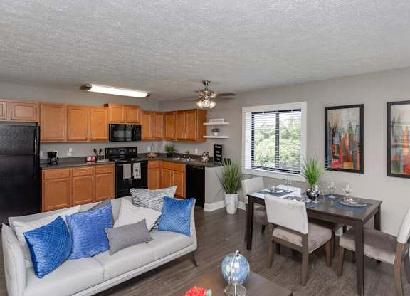 A well-lit kitchen with a dining table and chairs.