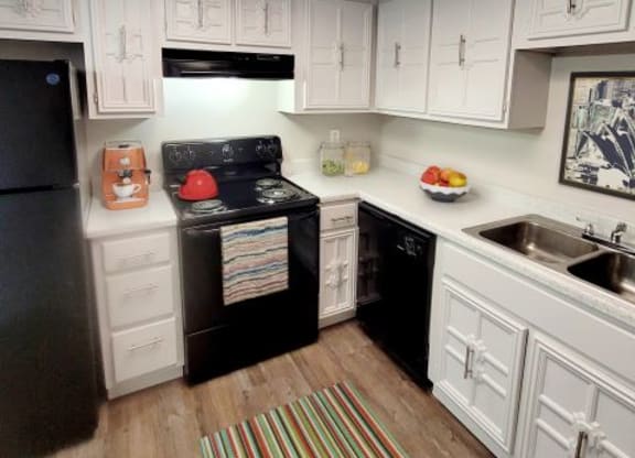 Kitchen with black appliances and white cabinets. 