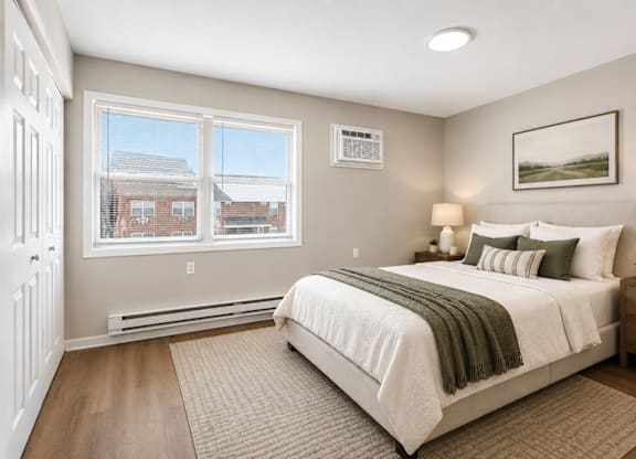 A bedroom with a large bed and a window overlooking a residential area.