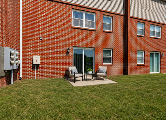 A red brick building with a green lawn in front.