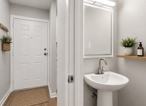 A white bathroom with a sink and mirror.