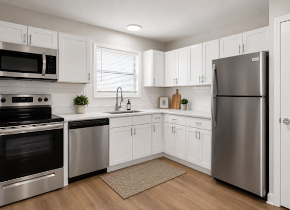 A modern kitchen with stainless steel appliances and white cabinets.
