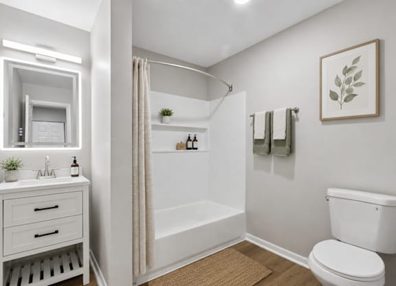 A white bathroom with a toilet, sink, and bathtub.