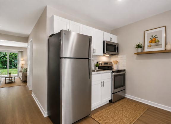 A modern kitchen with a refrigerator, microwave, and oven.