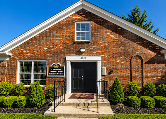 A brick building with a sign that says "Clubhouse Fitness Center Business Centre".