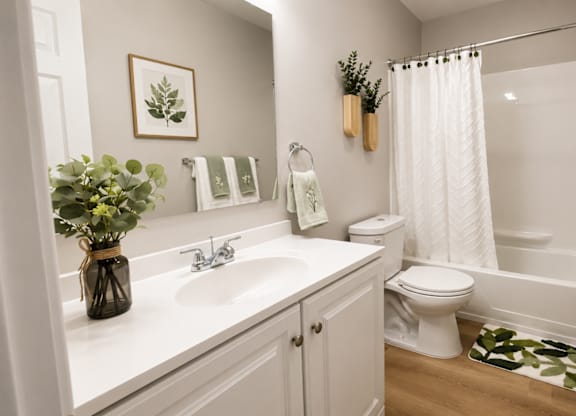 A bathroom with a white sink, toilet, and bathtub.