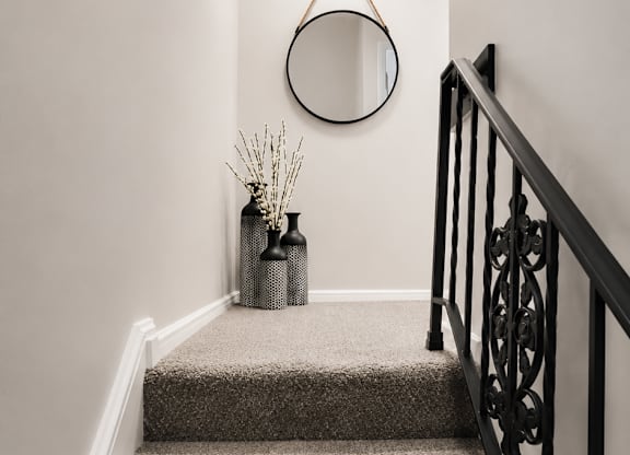 A staircase with a black railing and a hanging decoration.