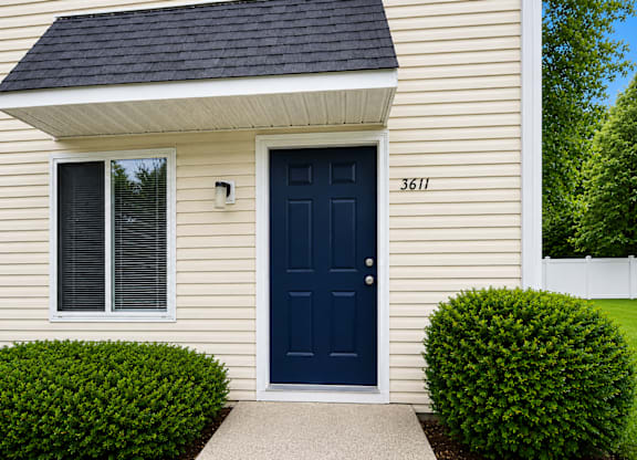 A house with a blue door and a window with blinds.