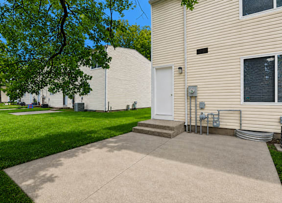 A beige building with a white door and a small porch.