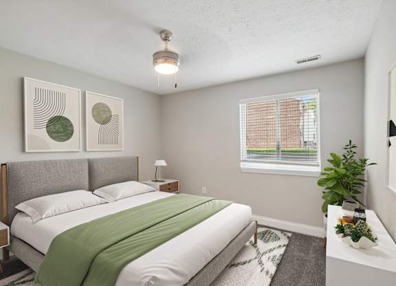 A bedroom with a bed, nightstand, and window.