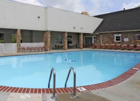 Outdoor pool with numerous seating options.  
