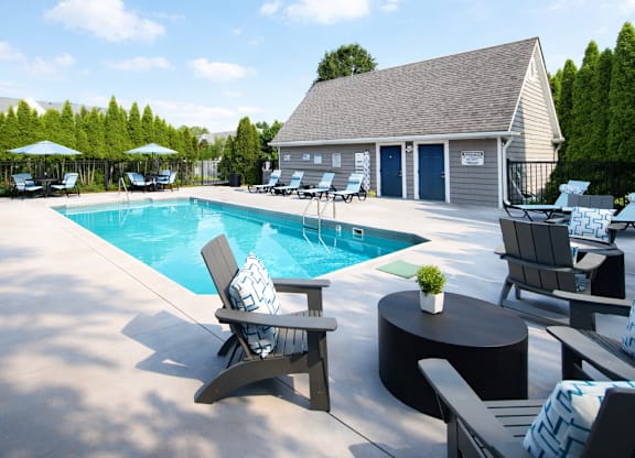 A poolside area with chairs and a table.