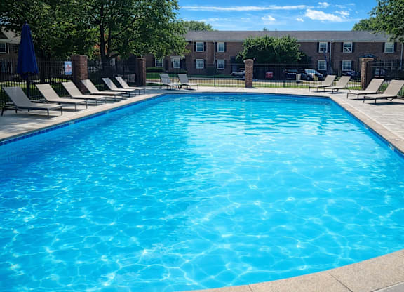 A large blue swimming pool surrounded by lounge chairs.