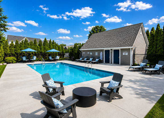 A large swimming pool with a slide and sun loungers.