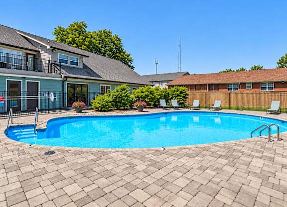 A swimming pool surrounded by a brick patio.