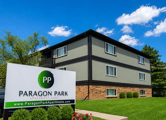 A Paragon Park Apartments sign in front of a building.