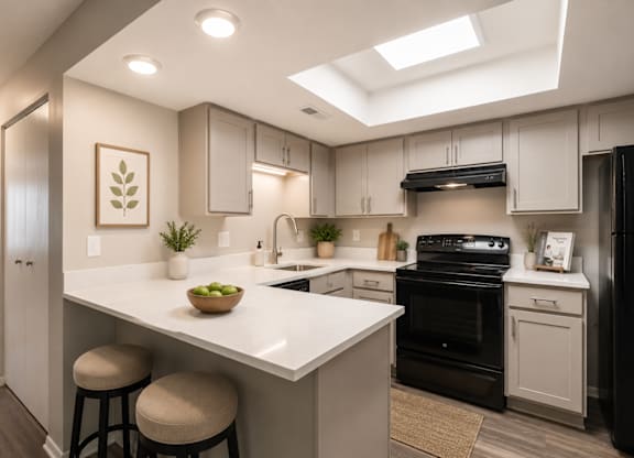 A modern kitchen with black appliances and white countertops.