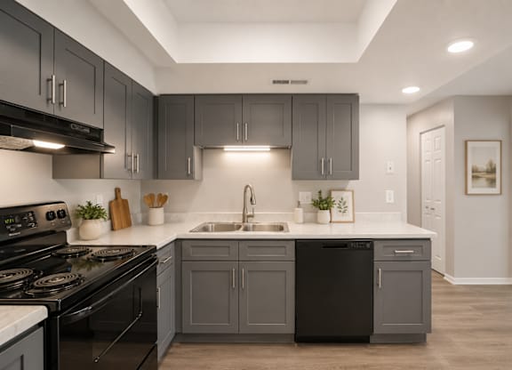 A modern kitchen with dark grey cabinets and white countertops.