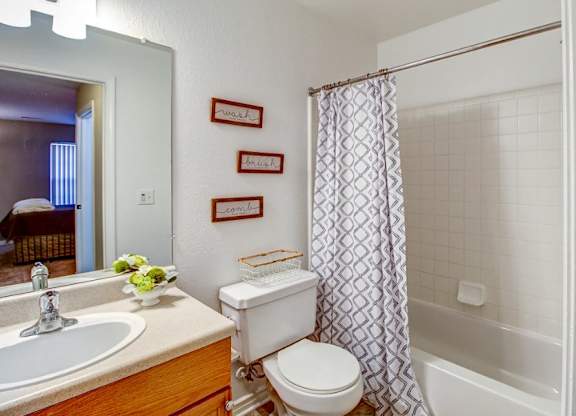 A white toilet sits next to a sink in a bathroom.