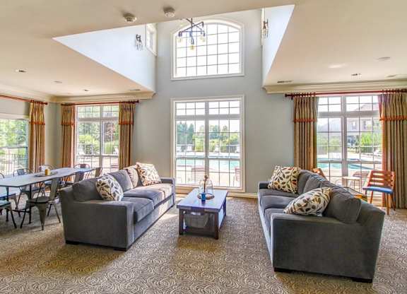 A living room with two grey couches and a table in the middle.