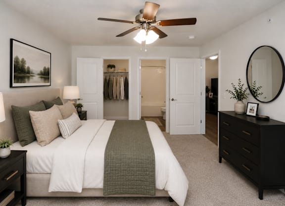 A bedroom with a large bed and a ceiling fan.