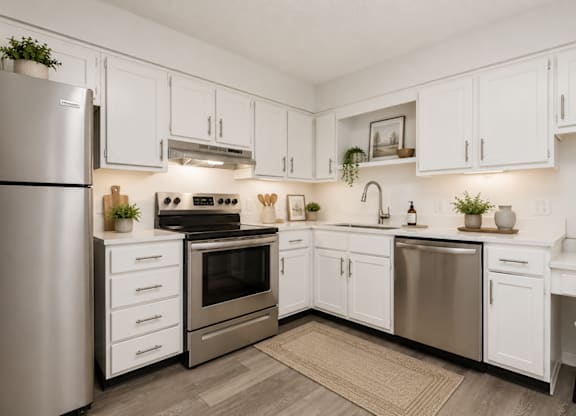 A modern kitchen with white cabinets and stainless steel appliances.