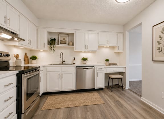 A kitchen with white cabinets and a black stove top oven.