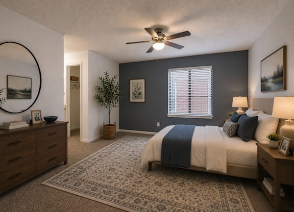 A bedroom with a large bed and a ceiling fan.