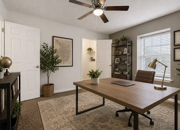 A room with a brown table and a laptop on it.