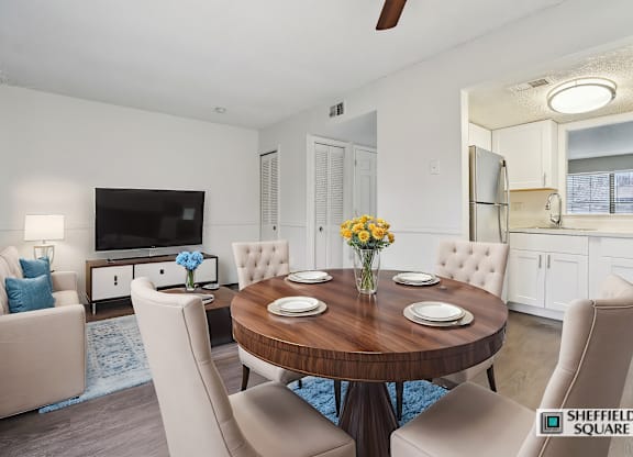 A modern dining room with a wooden table and white chairs.
