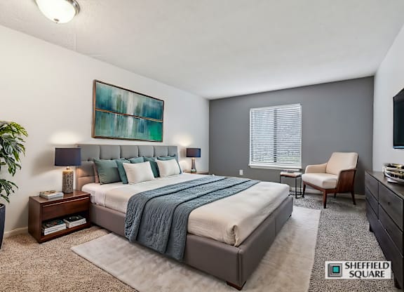 A bedroom with a large bed and a painting on the wall.