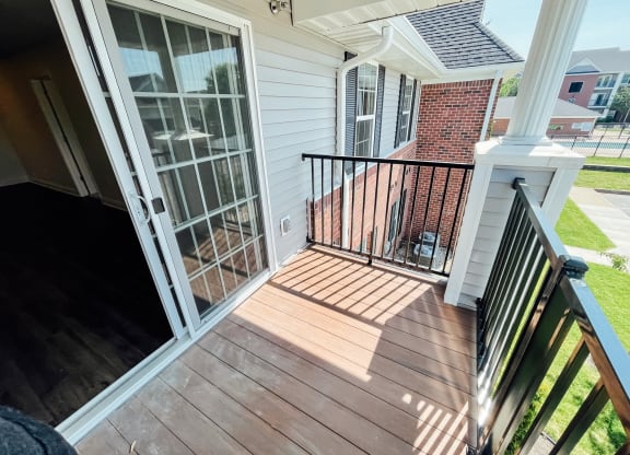 a view of the front porch of a white house with a balcony and a door