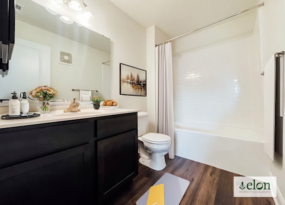 A bathroom with a toilet, sink, and mirror.