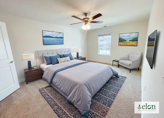 A bedroom with a large bed and a ceiling fan.