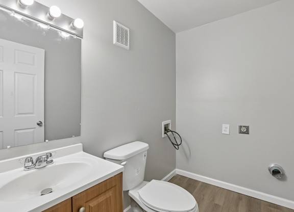 A white toilet sits next to a sink in a bathroom.