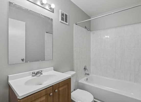 A white bathroom with a sink, toilet, and bathtub.