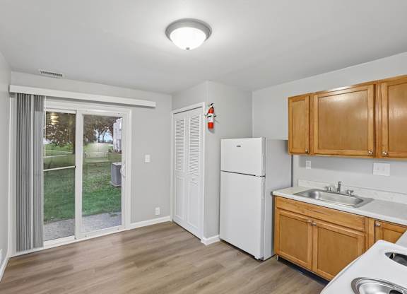 A kitchen with wooden cabinets and a white refrigerator.