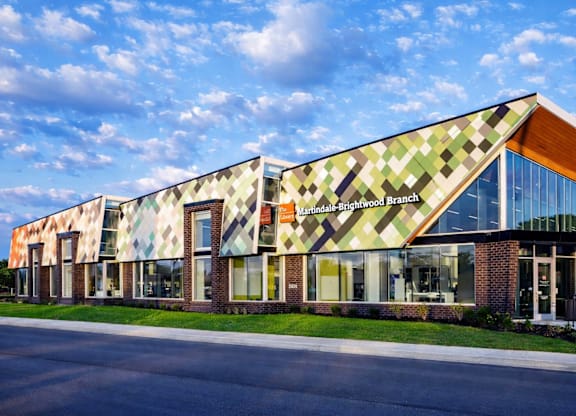 A modern building with a glass facade and a brick base.