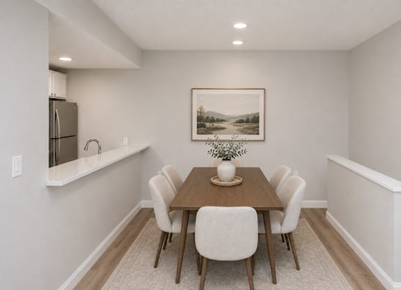 A dining room with a wooden table and chairs.