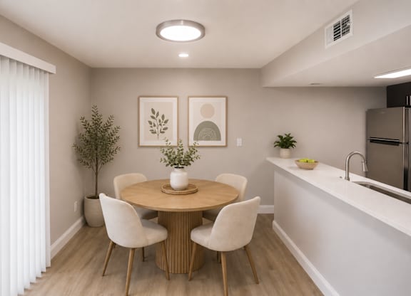 A dining room with a round table and chairs.