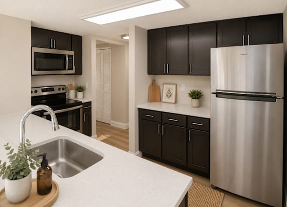 A kitchen with a white counter top and a stainless steel refrigerator.