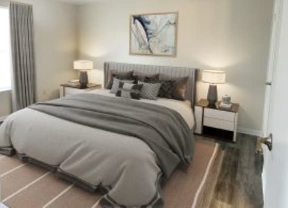 Hardwood-style flooring bedroom with a bed in between two nightstands, white walls, and a window.