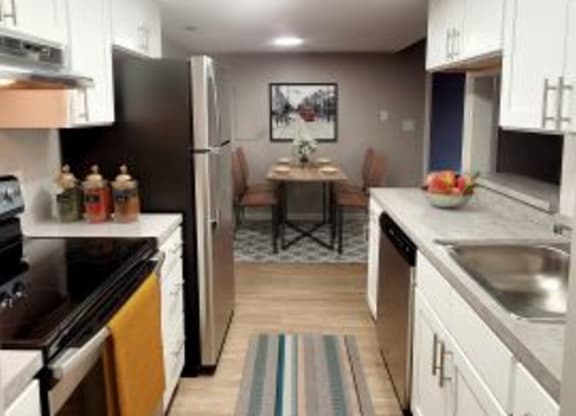 Kitchen with stainless steel appliances and white cabinets. 