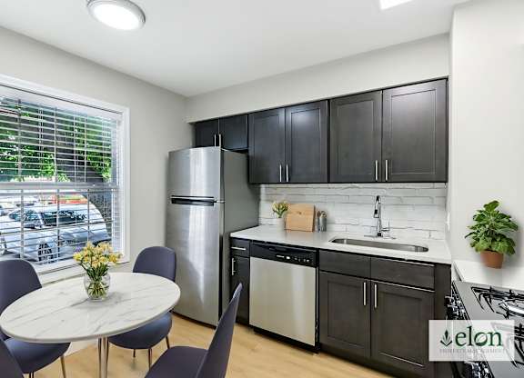 A modern kitchen with a dining table and chairs.