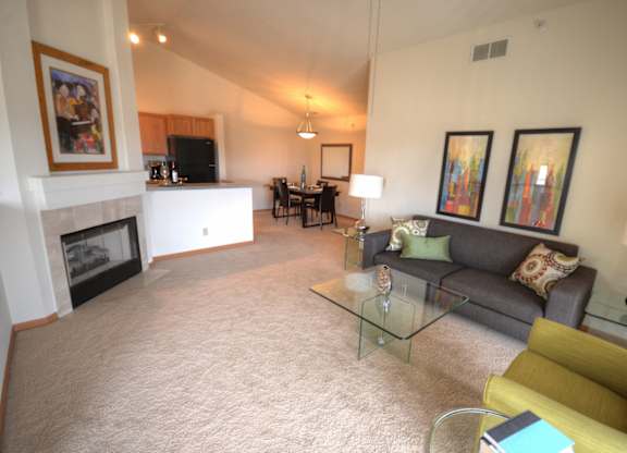 a living room with a couch and a table and a fireplace