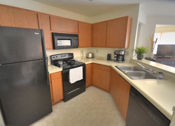 a kitchen with black appliances and wooden cabinets