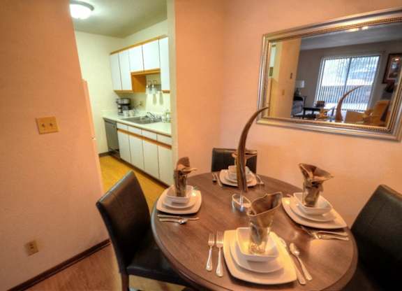 a dining room with a table and a mirror