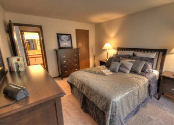 a bedroom with a bed and a dresser and a mirror