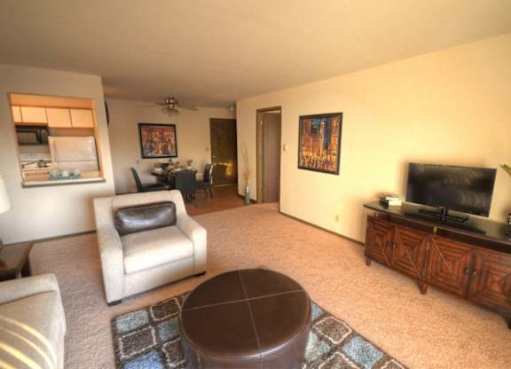 a living room with a couch and a chair and a television