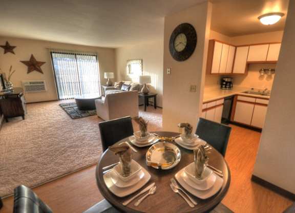 an open living room with a dining room table and a kitchen